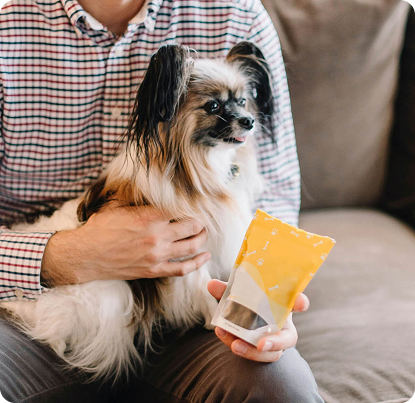 Man holding dog with calming chew product